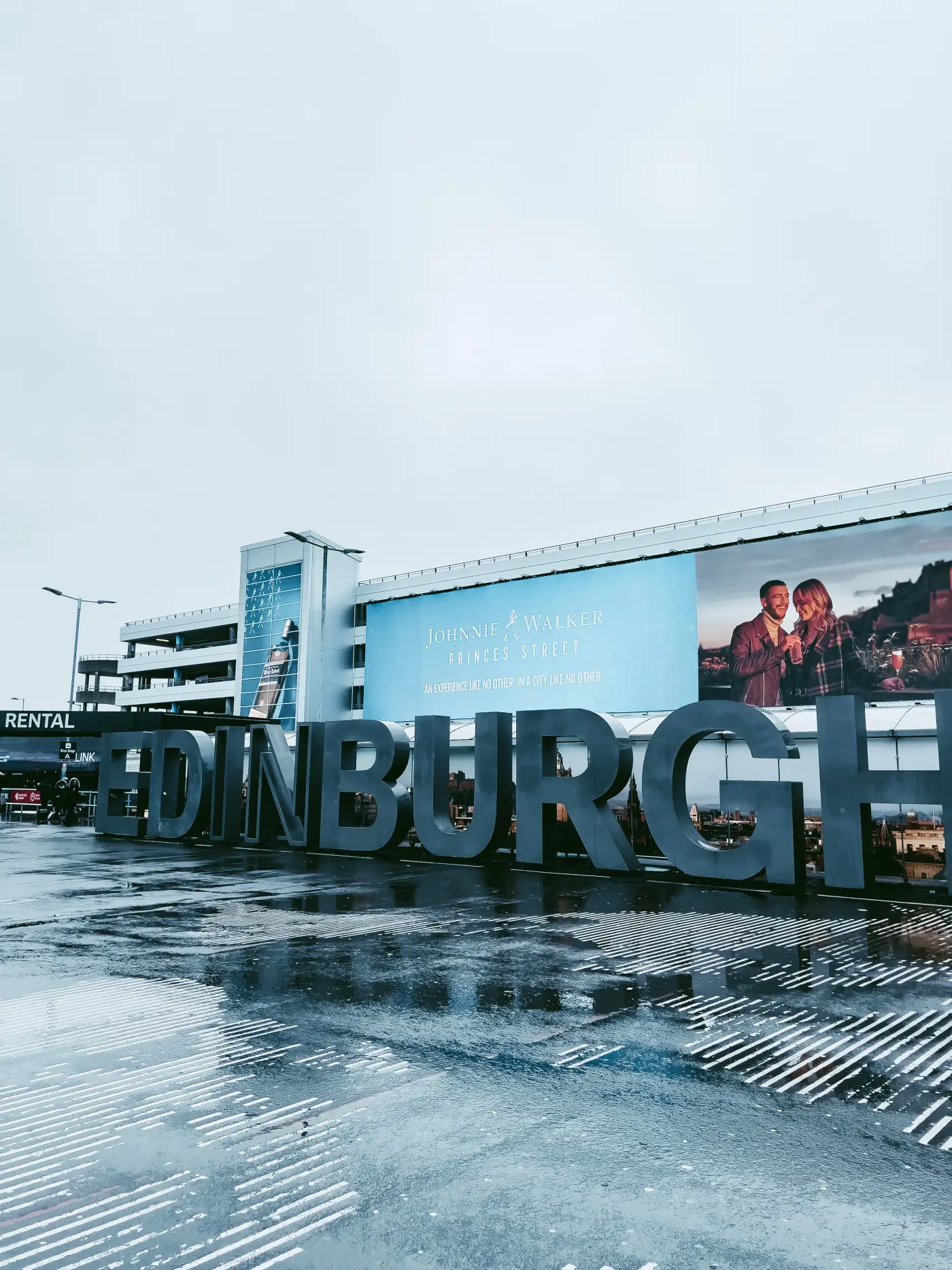 Zdjęcie napisu Edinburgh na edynburskim lotnisku podczas deszczu.